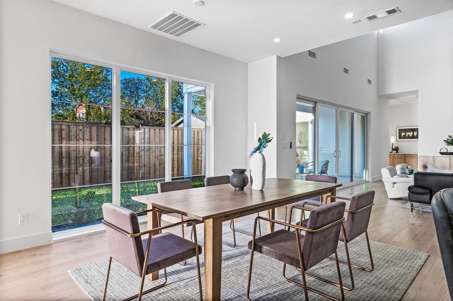 Dining area featuring a towering ceiling and light wood-type flooring