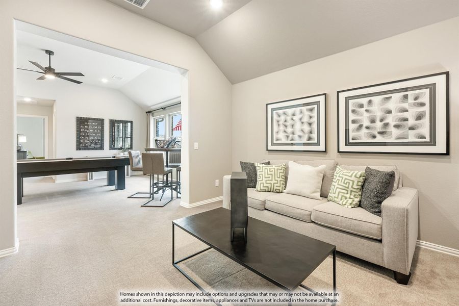 Living room with gray sofa and framed wall art, open to game room with pool table and ceiling fan