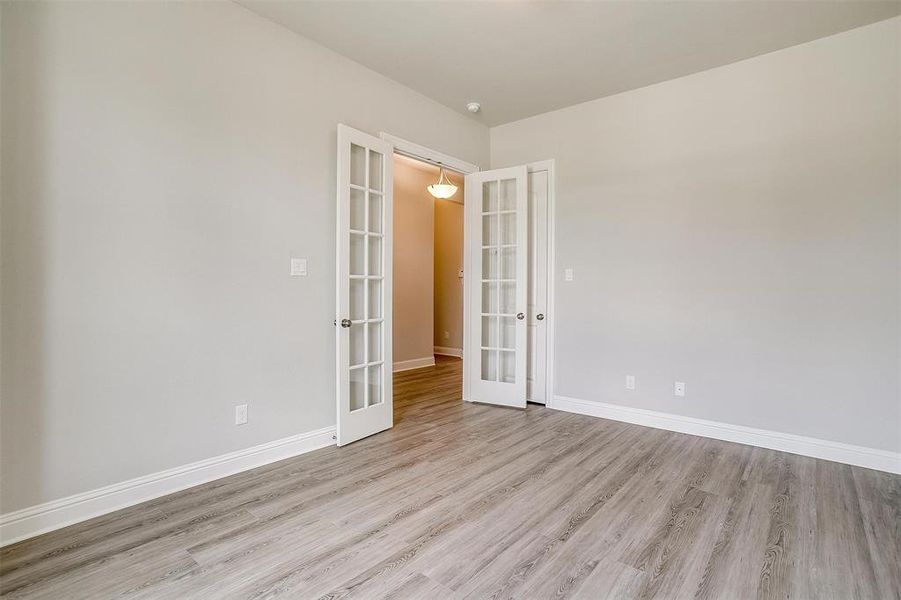 Unfurnished room with light hardwood / wood-style flooring and french doors