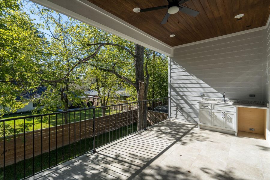 Enjoy outdoor living year-round in this spacious covered patio featuring recessed lighting, a ceiling fan, and built-in cabinetry Enjoy outdoor living year-round in this spacious covered patio featuring recessed lighting, a ceiling fan, and built-in cabinetry