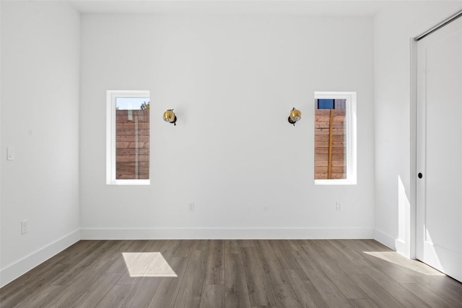 Unfurnished room with wood finished floors and baseboards Unfurnished room with wood finished floors and baseboards