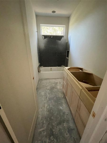 Bathroom with a tub/shower combo and vanity space awaiting final finishes. Bathroom with a tub/shower combo and vanity space awaiting final finishes.