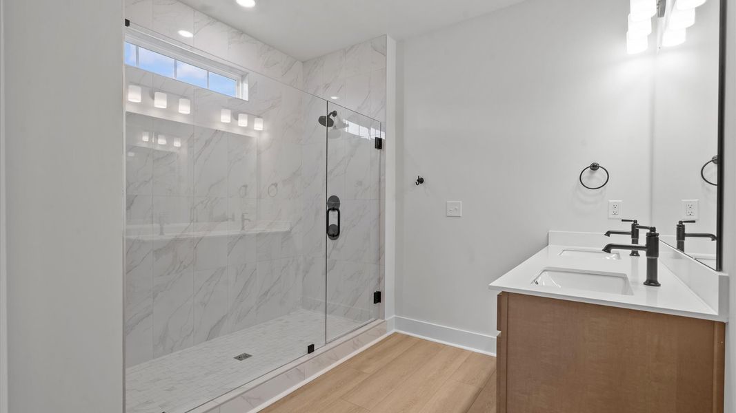 Highly functional and elegant en-suite with dual vanities, tiled walk-in shower, and refined finishes