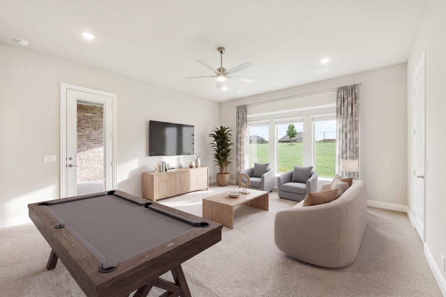 Game room with pool table, wall-mounted TV, seating area, and large windows overlooking backyard
