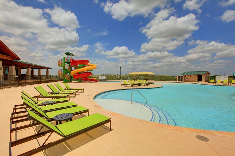 View of swimming pool with a water slide and a patio