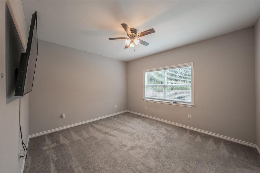 Spare room featuring light carpet and a ceiling fan Spare room featuring light carpet and a ceiling fan