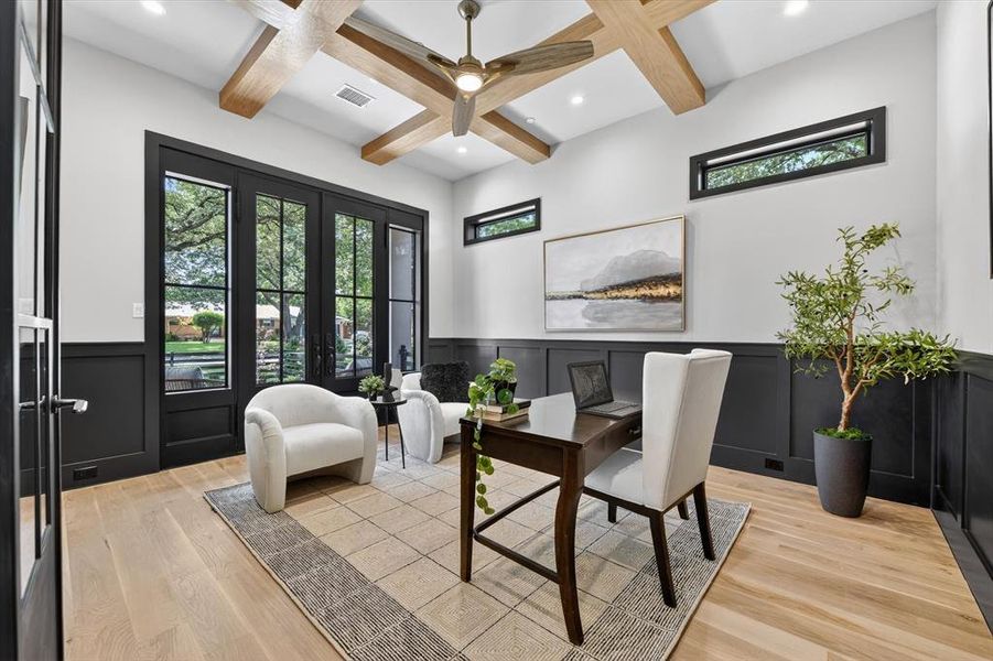 Room featuring a coffered ceiling with wood-finish beams, light wood-finish flooring, and a ceiling fan with integrated lighting Room featuring a coffered ceiling with wood-finish beams, light wood-finish flooring, and a ceiling fan with integrated lighting