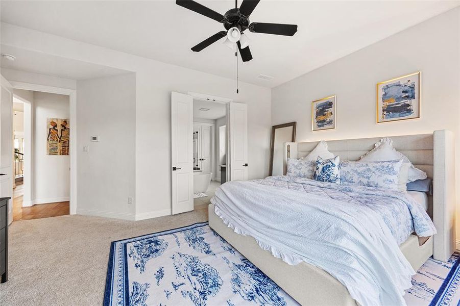 Carpeted bedroom featuring baseboards, ceiling fan, and visible vents