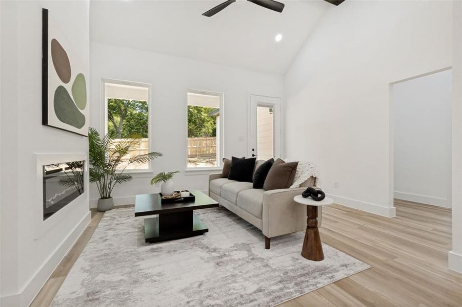 Living space featuring a vaulted ceiling and light wood-finish flooring Living space featuring a vaulted ceiling and light wood-finish flooring