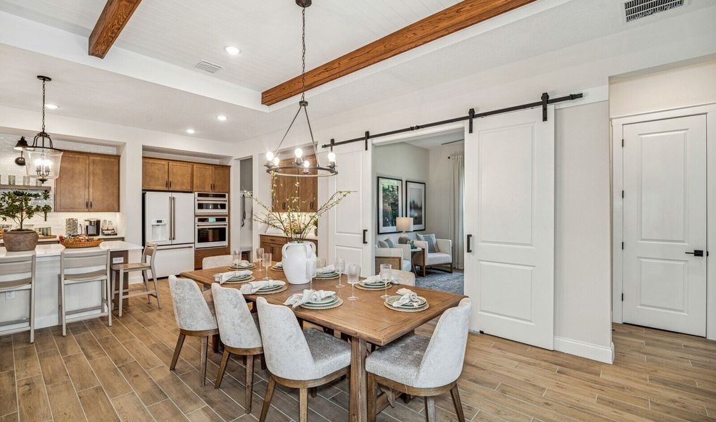 Dining area with sliding barn doors to private home office