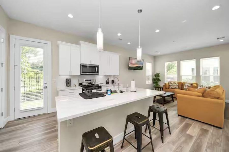 A clean, bright kitchen pairs white cabinetry and countertops with stainless steel appliances for a look that is easy to move into and make your own.