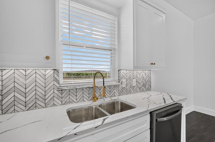Kitchen sink area featuring a dual stainless steel sink with a gold-tone gooseneck faucet