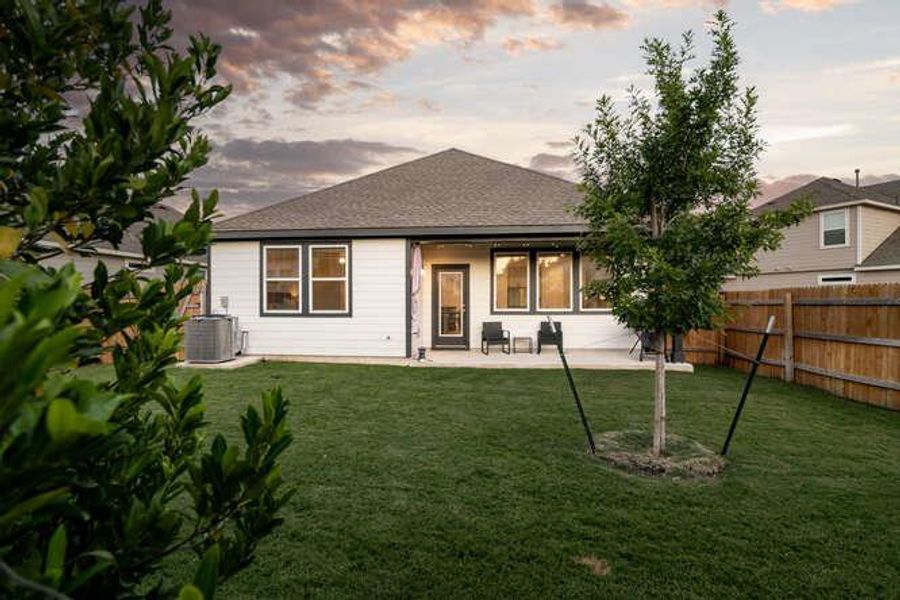 Rear view of house with a patio and a shingled roof