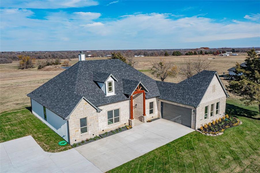 View of front of house featuring a front yard and a garage