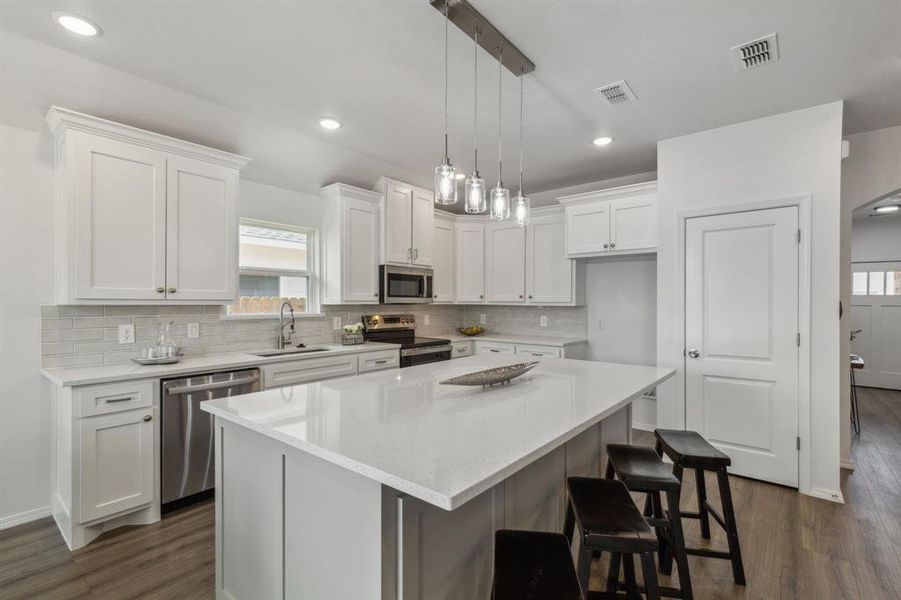 Kitchen featuring white cabinetry, dark hardwood / wood-style flooring, appliances with stainless steel finishes, and sink