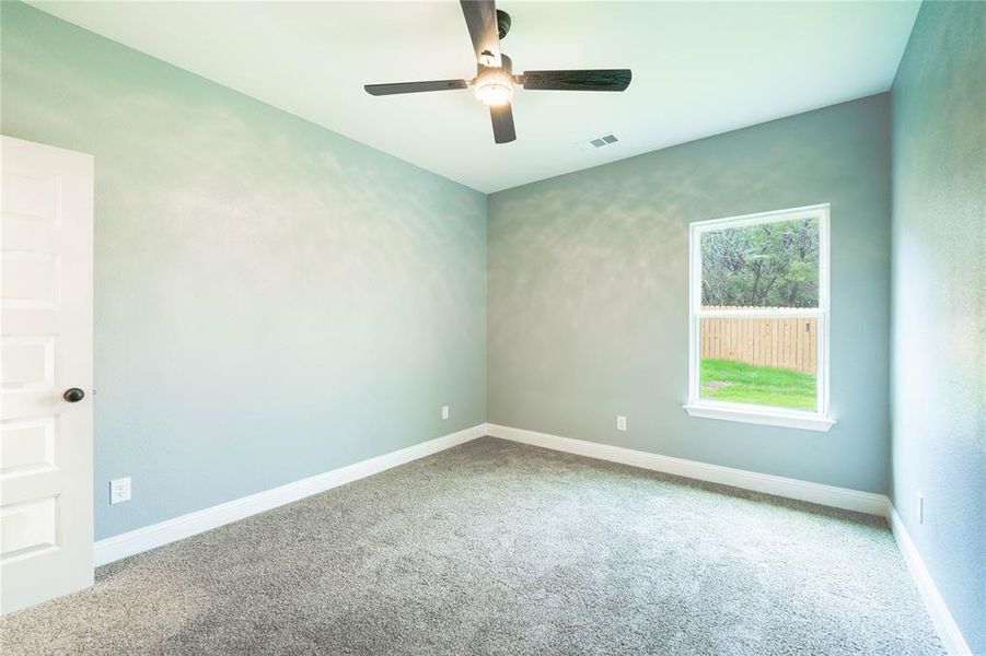 Empty room with ceiling fan and carpet flooring