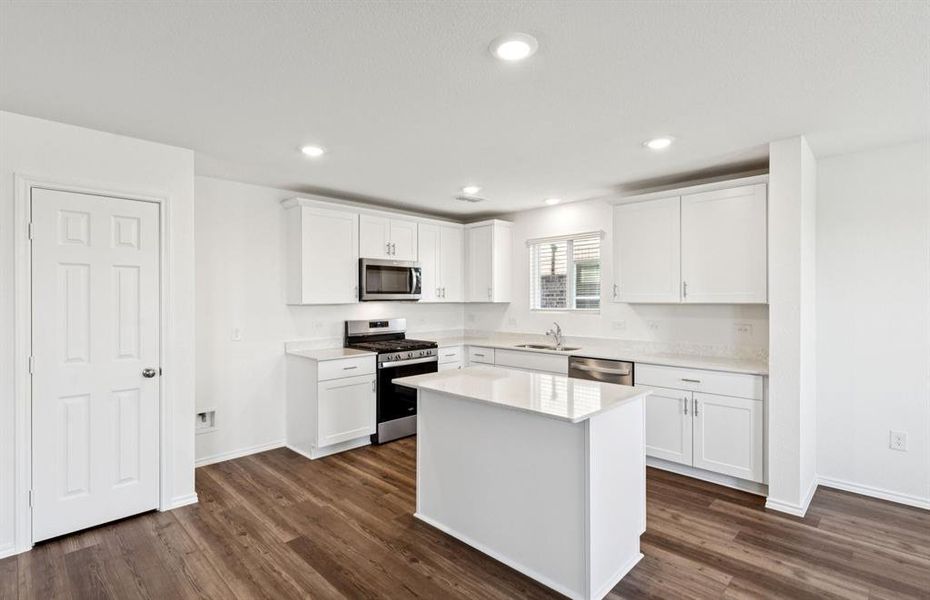 Large island overlooking gathering room and dining areas