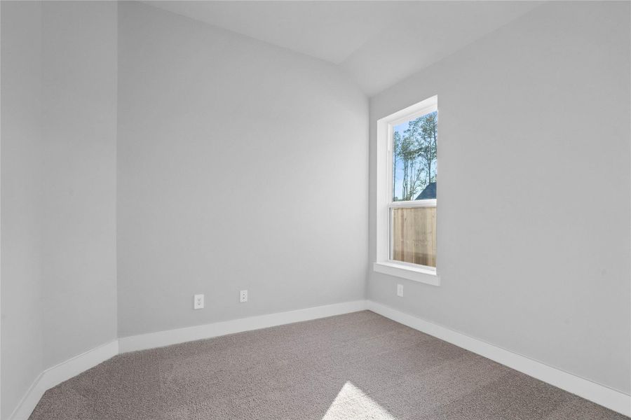 Discover a peaceful sanctuary in this inviting secondary bedroom, perfectly designed for comfort. It features sloped ceiings and a generously sized window providing ample natural light.