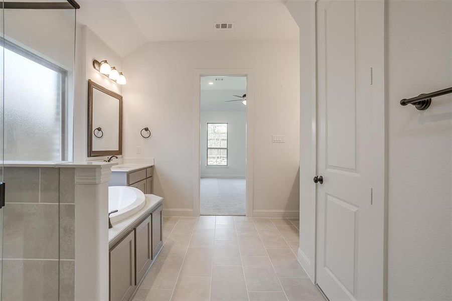 Bathroom featuring vanity, a bath, ceiling fan, and tile patterned flooring