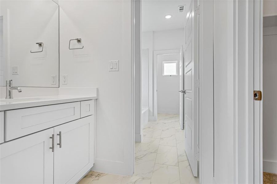 Bathroom featuring vanity, tub / shower combination, and tile patterned flooring