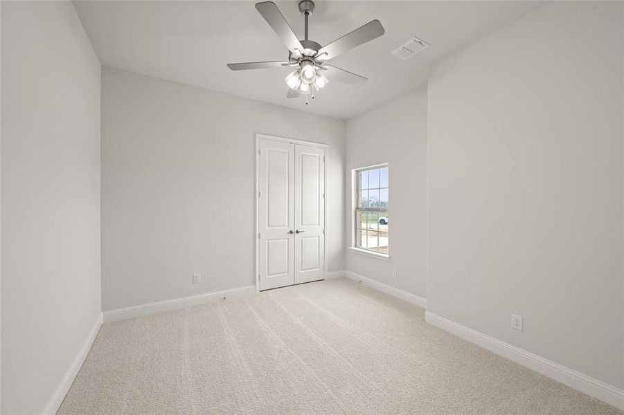 Unfurnished bedroom featuring light carpet, baseboards, a closet, and a ceiling fan Unfurnished bedroom featuring light carpet, baseboards, a closet, and a ceiling fan