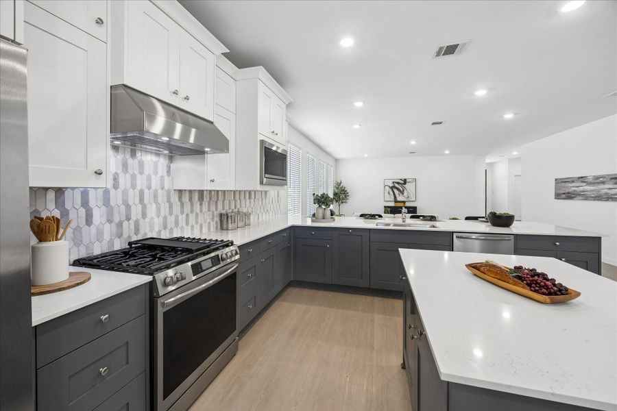 Your inner chef gets plenty to work with here, including a stainless steel gas range with griddle cooktop, statement vent hood, built in microwave and dishwasher, all surrounded by contrasting cabinetry and ample counter space.