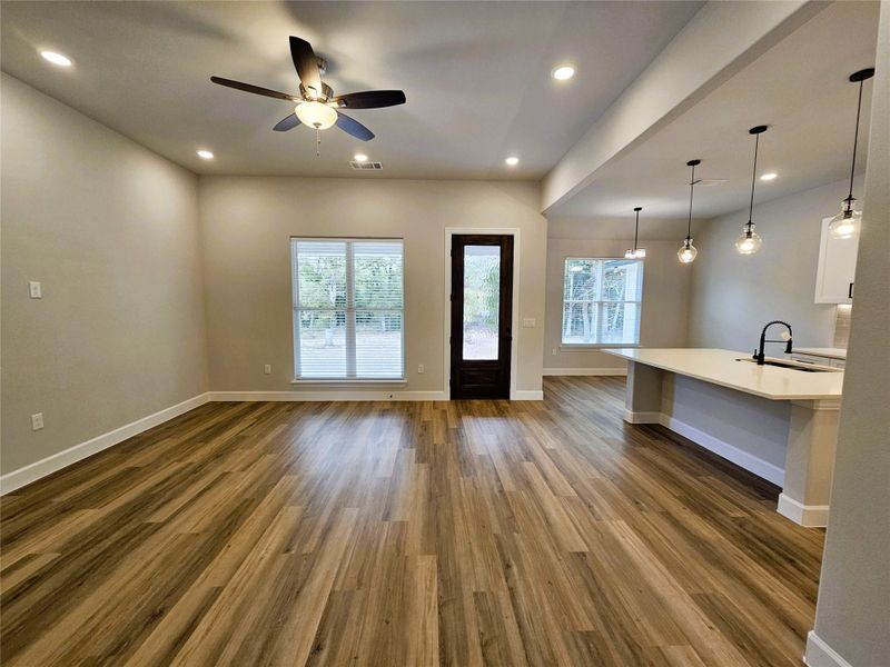 Unfurnished living room featuring recessed lighting, dark wood-type flooring, healthy amount of natural light, and a ceiling fan