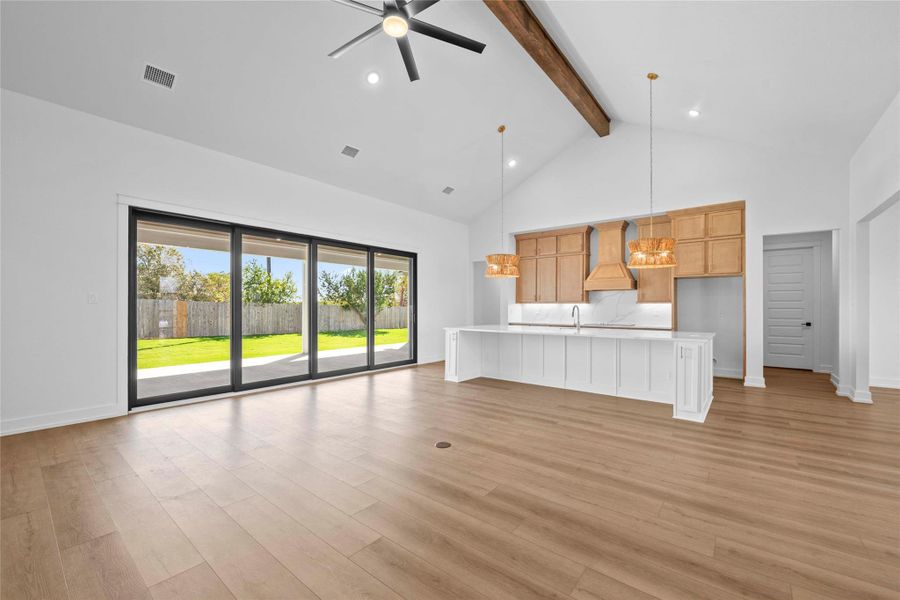 Unfurnished living room with high vaulted ceiling, recessed lighting, beamed ceiling, light wood-style flooring, and a ceiling fan Unfurnished living room with high vaulted ceiling, recessed lighting, beamed ceiling, light wood-style flooring, and a ceiling fan