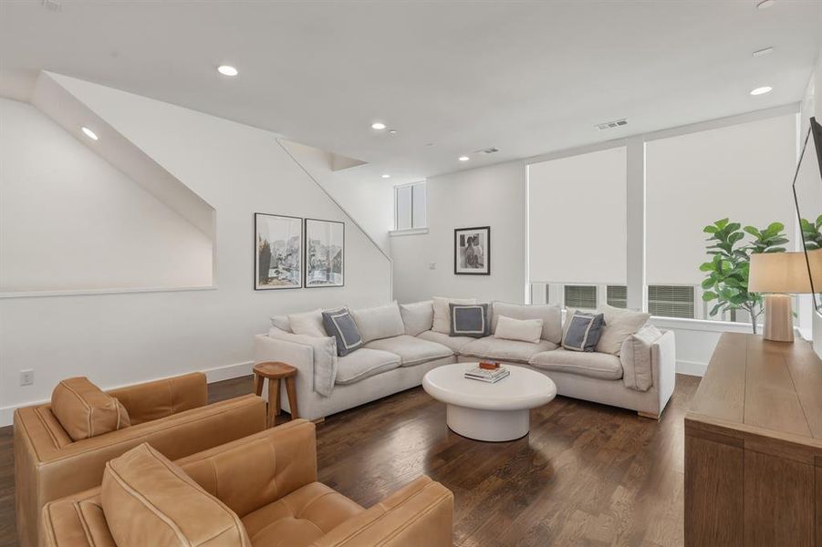 Living room with dark wood-style flooring and recessed lighting