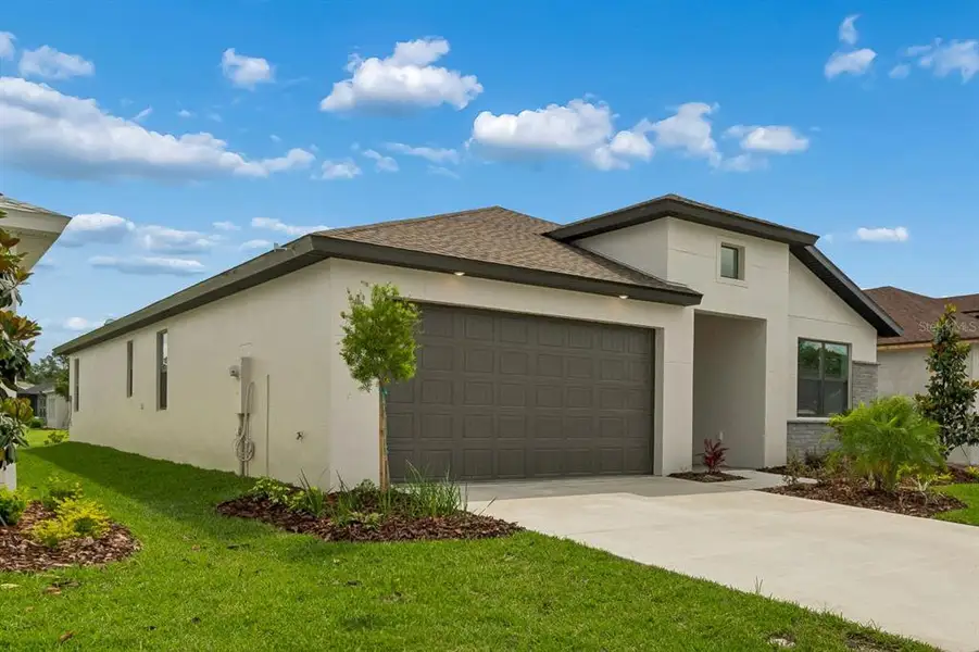Front exterior of a new home in Isles at Bayview, Parrish, FL, highlighting curb appeal (Image 27). Front exterior of a new home in Isles at Bayview, Parrish, FL, highlighting curb appeal (Image 27).