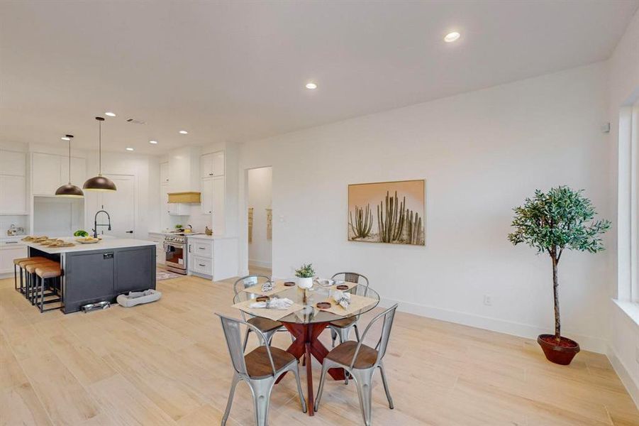 Dining area with baseboards, light wood-type flooring, and recessed lighting