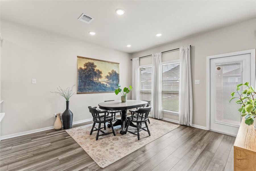 Recessed lighting illuminates the casual dining space, featuring wood flooring and ample natural light from multiple windows. Recessed lighting illuminates the casual dining space, featuring wood flooring and ample natural light from multiple windows.