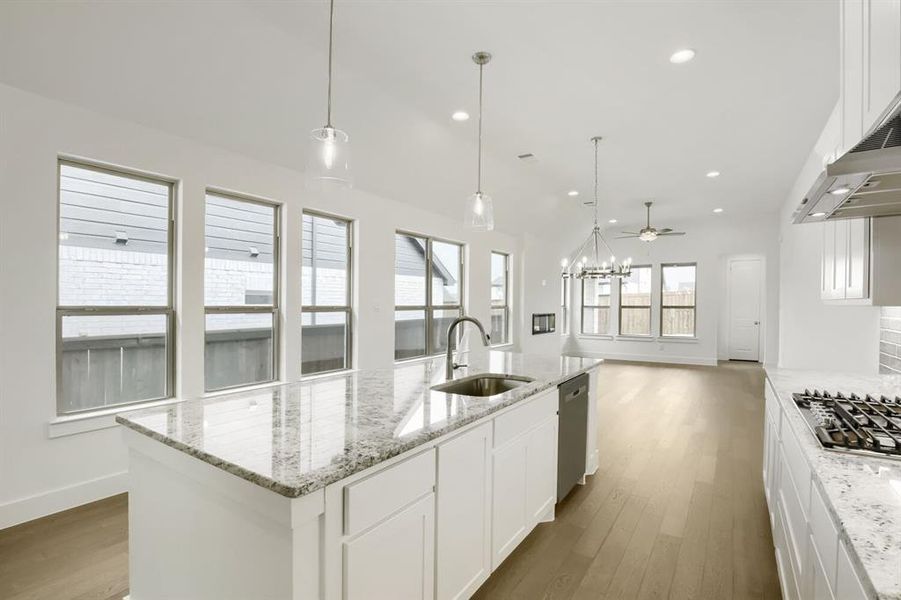 Expansive kitchen island featuring a stainless steel sink and integrated dishwasher