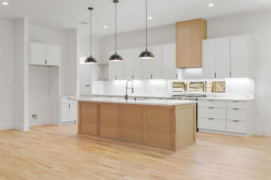 The crisp white cabinetry is beautifully contrasted by the warm wood-toned center island, while designer pendant lighting adds a sophisticated finishing touch. Together, these carefully selected elements create a kitchen that is as elegant as it is functional, making it the true centerpiece of the home. The crisp white cabinetry is beautifully contrasted by the warm wood-toned center island, while designer pendant lighting adds a sophisticated finishing touch. Together, these carefully selected elements create a kitchen that is as elegant as it is functional, making it the true centerpiece of the home.