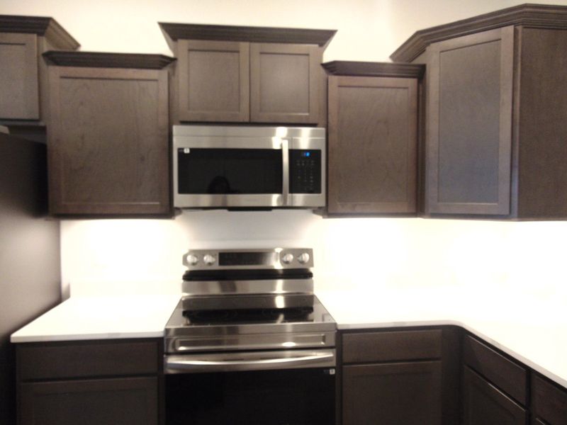 The kitchen is spacious and modern, it comes with steel appliances, and crown cabinetry for a unique look