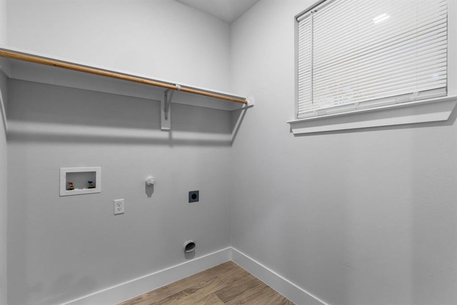 Laundry area featuring hardwood / wood-style floors, hookup for an electric dryer, gas dryer hookup, and hookup for a washing machine