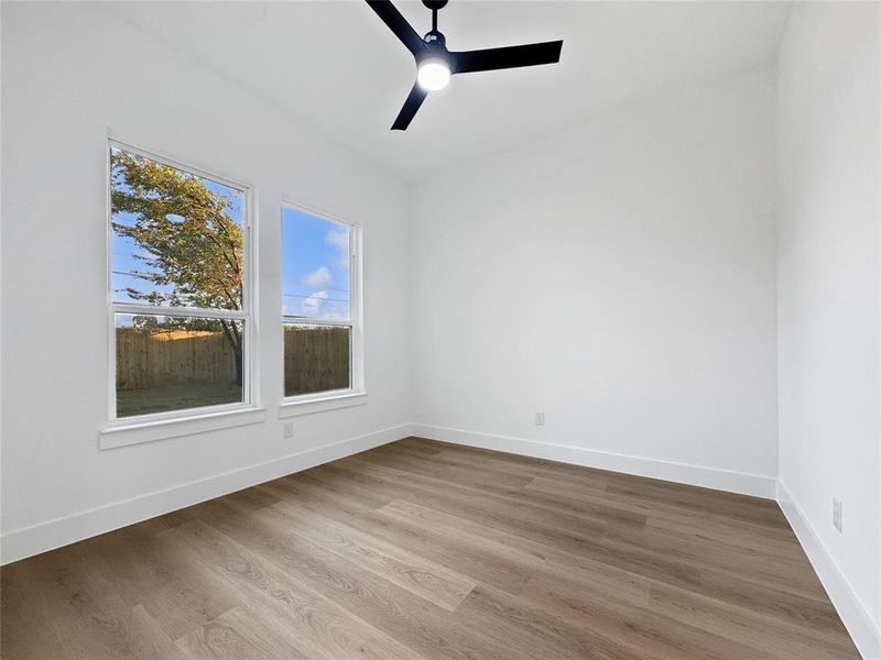 Spare room with wood finished floors and ceiling fan