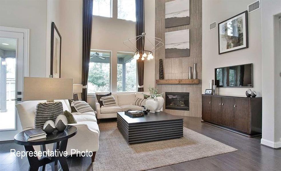 Living room with a large fireplace, dark hardwood / wood-style floors, and plenty of natural light