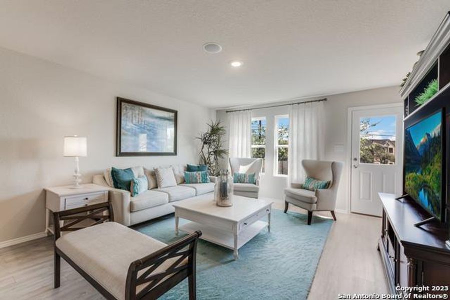 Living room featuring light wood finished floors and recessed lighting Living room featuring light wood finished floors and recessed lighting