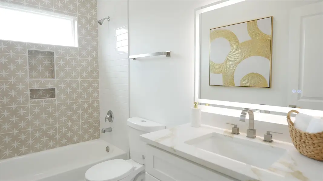 This modern bathroom features a stylish blend of patterned and subway tiles, a large illuminated mirror, and a tub-shower combo. Bright and inviting, it offers ample storage and contemporary fixtures. This modern bathroom features a stylish blend of patterned and subway tiles, a large illuminated mirror, and a tub-shower combo. Bright and inviting, it offers ample storage and contemporary fixtures.