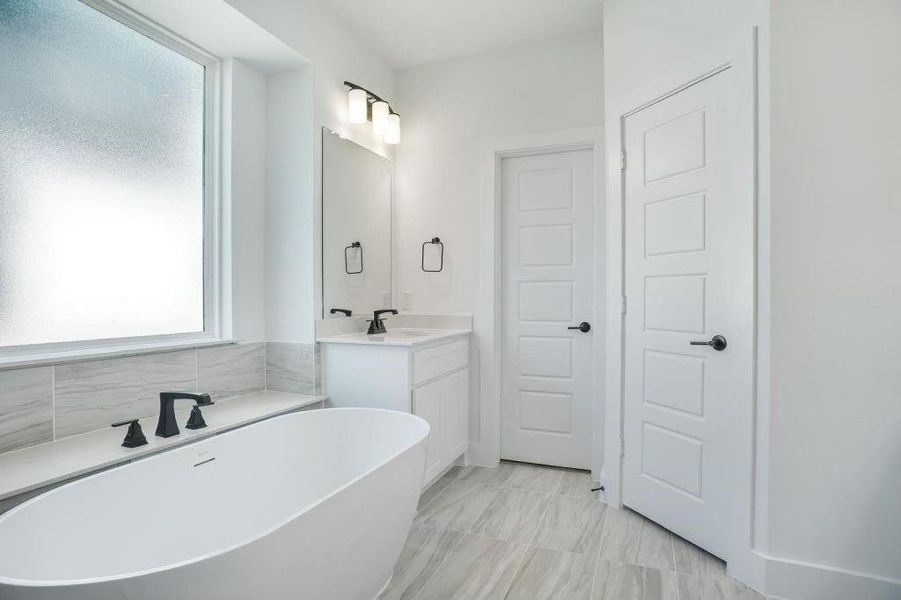 Bathroom featuring vanity and a bath