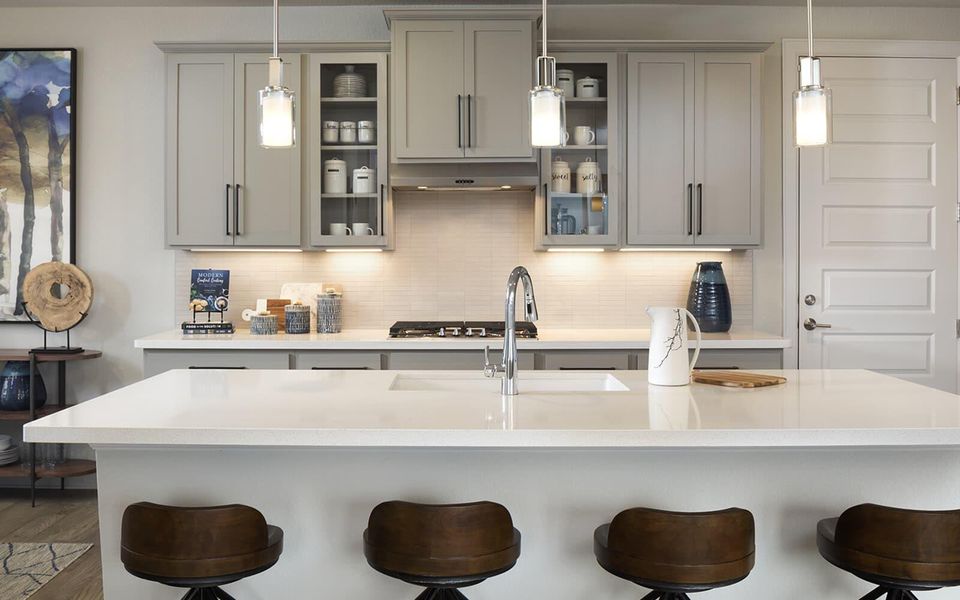 Kitchen with gray cabinetry, a breakfast bar, and decorative backsplash Kitchen with gray cabinetry, a breakfast bar, and decorative backsplash
