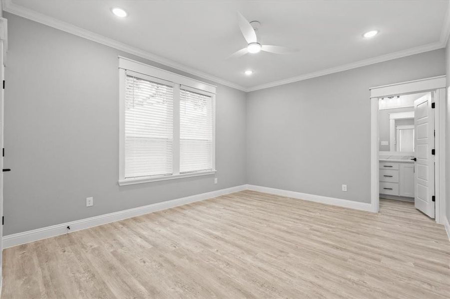 Unfurnished bedroom with ceiling fan, ornamental molding, ensuite bath, and light hardwood / wood-style floors