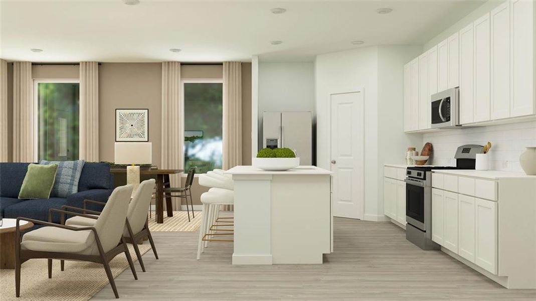 Kitchen featuring white cabinets, stainless steel appliances, a breakfast bar area, and an island with sink