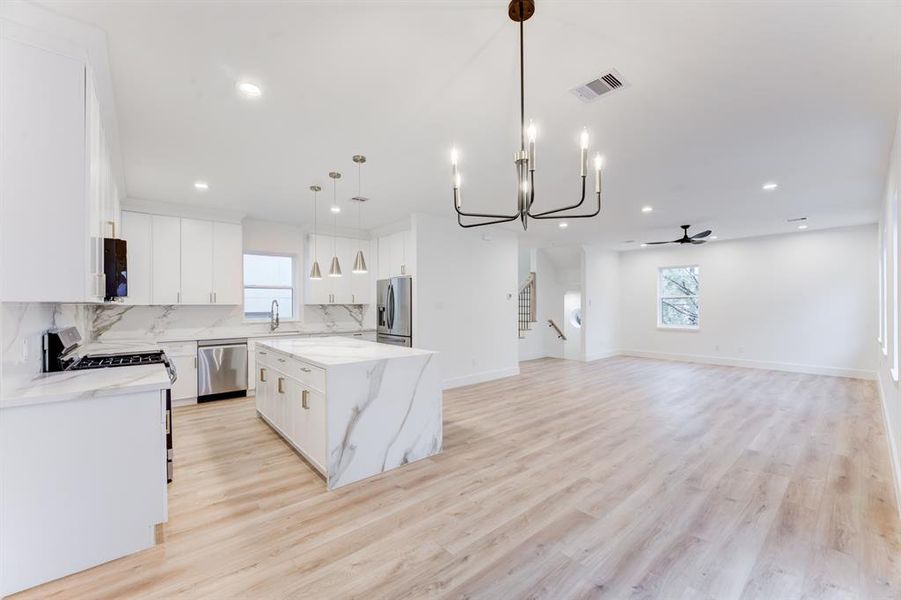 The dining area is open to the kitchen, living room. It has an elegant light fixture.