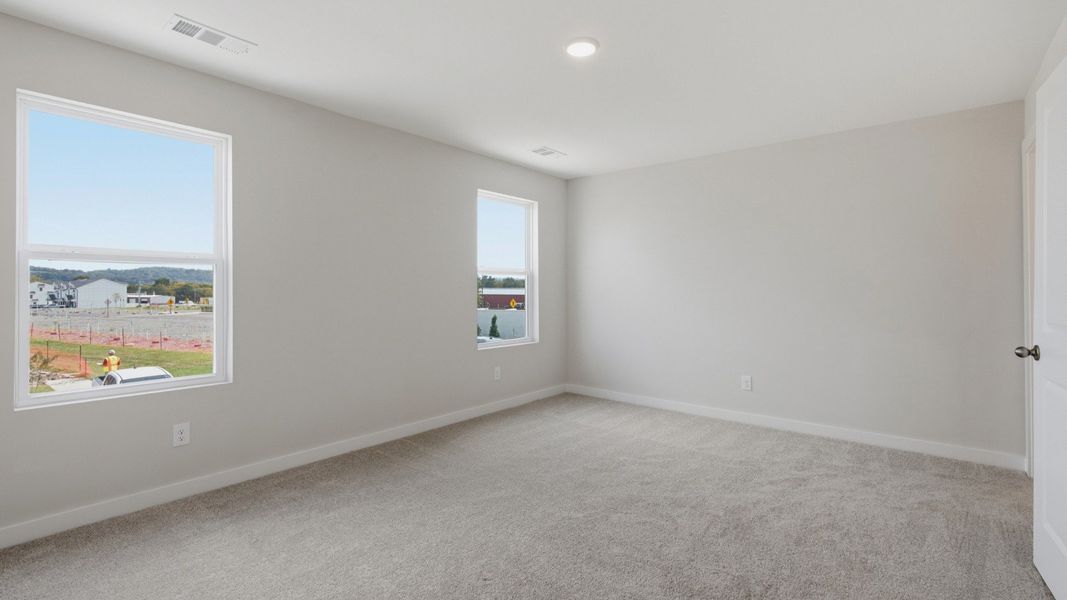 Spacious primary bedroom with connected bathroom and walk-in closet