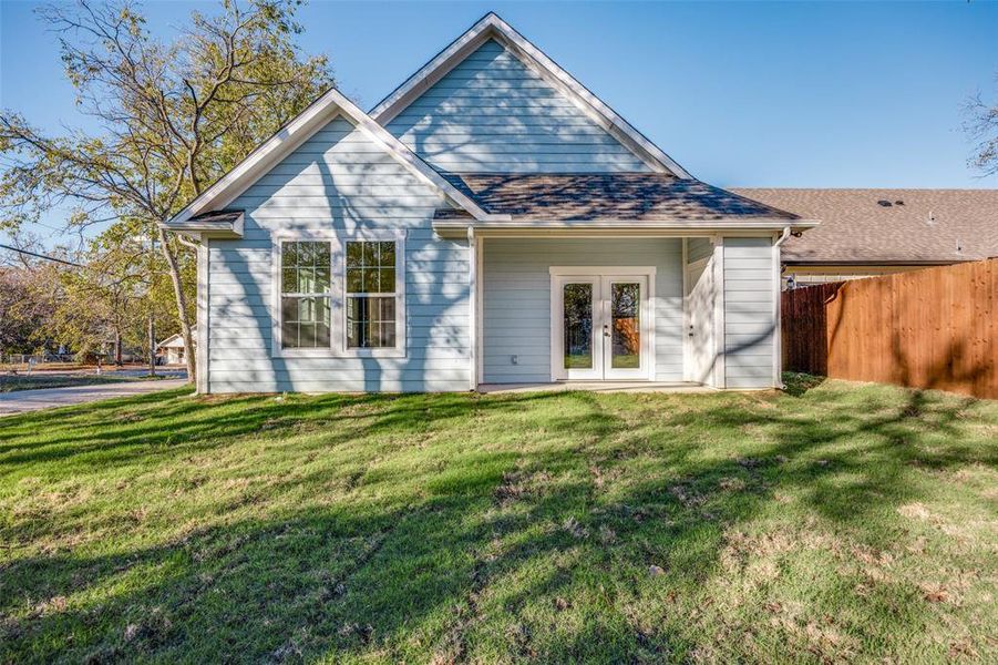 Back of house with a lawn and french doors