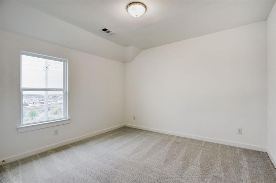 Carpeted interior room with white walls and a single window
