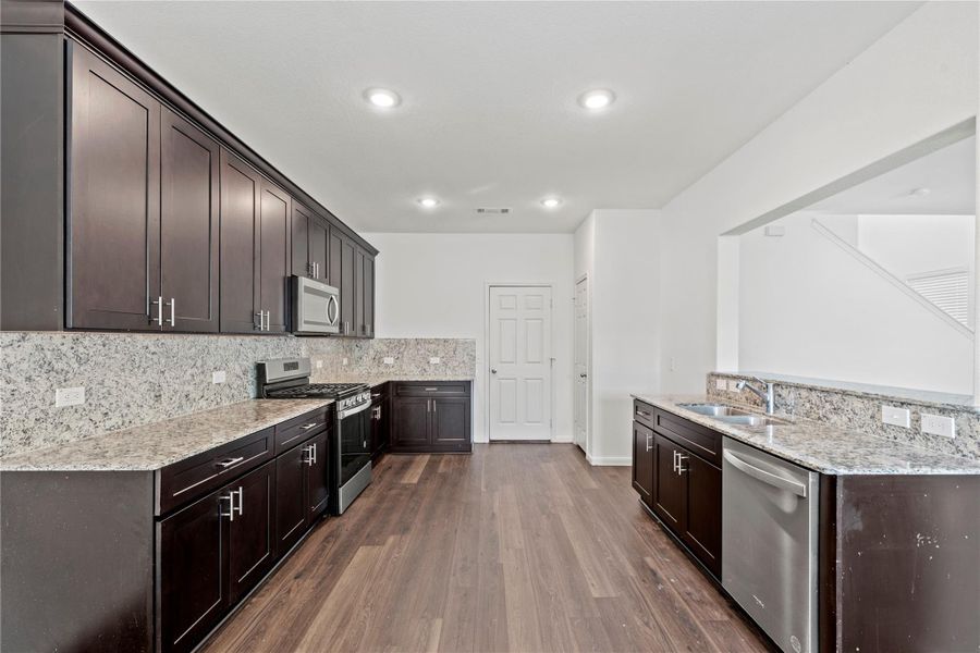 Well-appointed kitchen with granite countertops and backsplash, stainless steel appliances and a gas cooktop. Well-appointed kitchen with granite countertops and backsplash, stainless steel appliances and a gas cooktop.