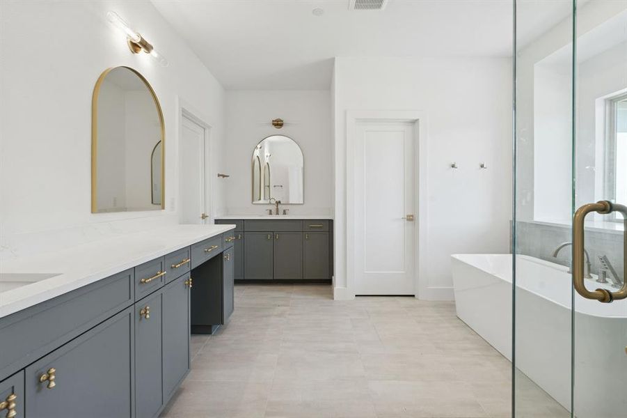 Primary bathroom with separate vanities.